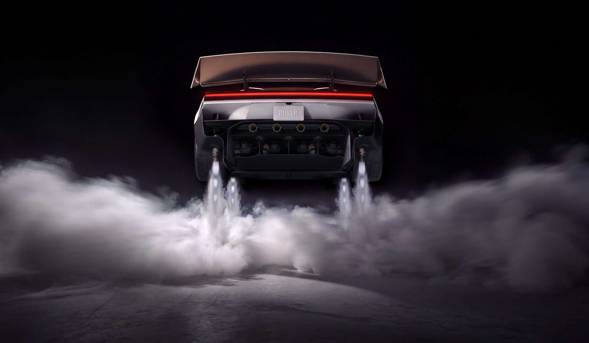Rear view of the Roadster with a large rear wing, white jets of gas streaming from nozzles beneath the car into a cloud on the ground